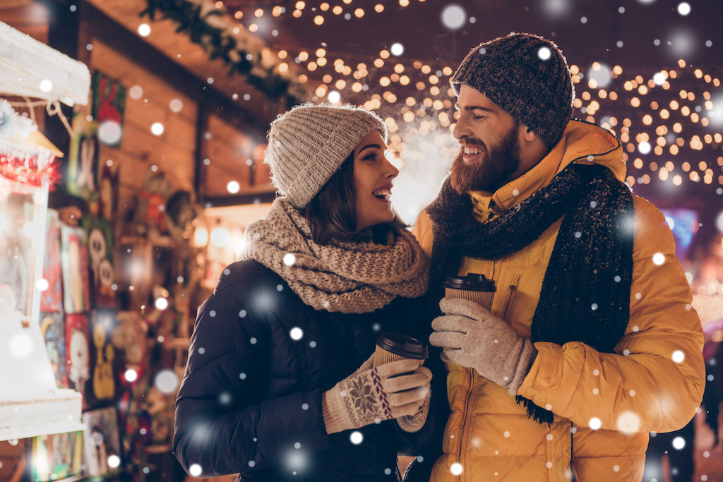 Couple walking along street with holiday lights